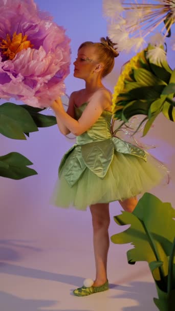 Χαριτωμένο Κορίτσι Πράσινο Κοστούμι Πεταλούδα Στέκεται Κοντά Λουλούδια — Αρχείο Βίντεο