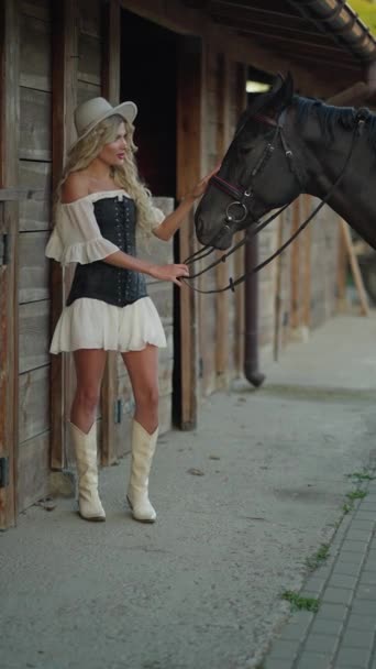 Beautiful Blonde Girl Holds Harnessed Horse Bridle Riding — Stock Video