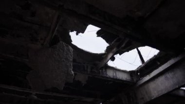 Düşman bombasıyla yok edilmiş bir evin çatısında bir delik.