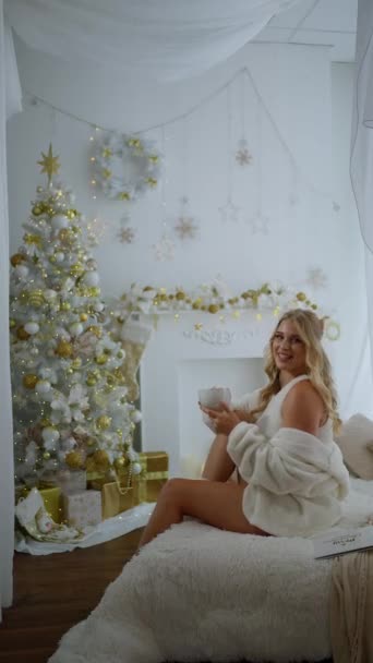Attractive Young Woman Enjoying Christmas Morning Smiling While Sitting Cozy — Stock Video