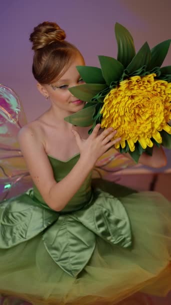 フォレストフェアリー 緑のドレスで妖精の美しさ 大きな花を保持しています 穏やかなメイクで妖精のお姫様 スタジオでポーズモデル — ストック動画