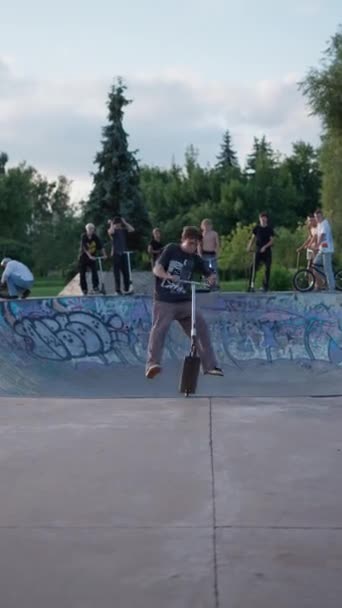 スケート バイク スクーターで夏の日に屋外でスクーターパークで遊んでいるティーンエイジャー スポーツ活動のコンセプト — ストック動画