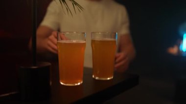 Bar masasında iki bardak biranın durduğu bir barı kapat. Barda bir bardak bira iç.