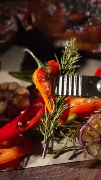 厨师用火钳把烤辣椒 百里香和大蒜放在一大块肉旁边 在餐馆准备和供应食物 — 图库视频影像