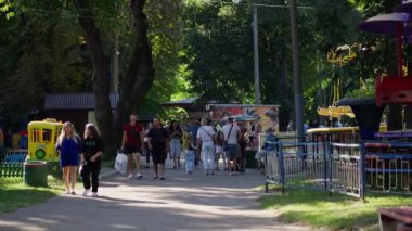 Ebeveynler ve çocuklar bir yaz günü eğlence parkında hafta sonu geçiriyorlar.