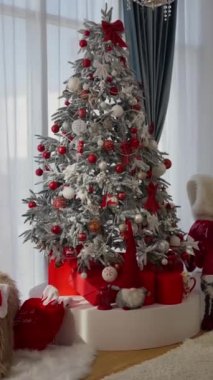 Odada Noel ağacı süslemeleri var. Noel ruhunu ve havasını yansıtan pırıl pırıl bir çelenk. Yılbaşı ve yeni yıl içinin olduğu bir oda. Yeşil ağaç, süslenmiş.
