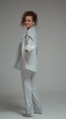 Gümüş elbiseli, takım elbiseli, pantolonlu ve sütyenli güzel bir kozmik esmer.