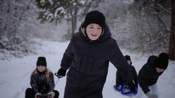 笑容满面的孩子们在雪地的森林里滑行 寒假的概念 孩子们在外面雪地里玩耍 圣诞假期 — 图库视频影像