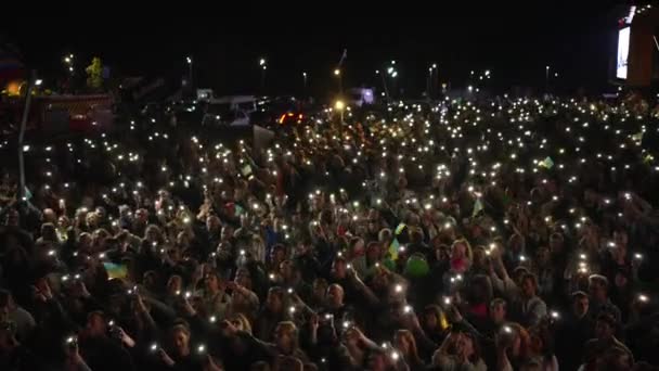 音乐爱好者在人群中 人群中 观众中 歌迷中通过电话记录视频 举手表决 欣赏现场音乐节活动 并在移动设备上点亮灯笼 — 图库视频影像