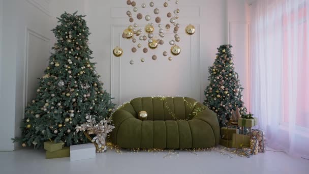 Boże Narodzenie Choinka Ozdobiona Złotymi Warstwami Błyszczące Girlandy Miękką Sofą — Wideo stockowe