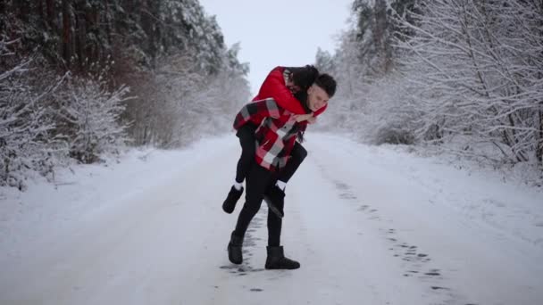 Feliz Jovem Casal Divertindo Dia Ensolarado Inverno Enquanto Caminhava Floresta — Vídeo de Stock