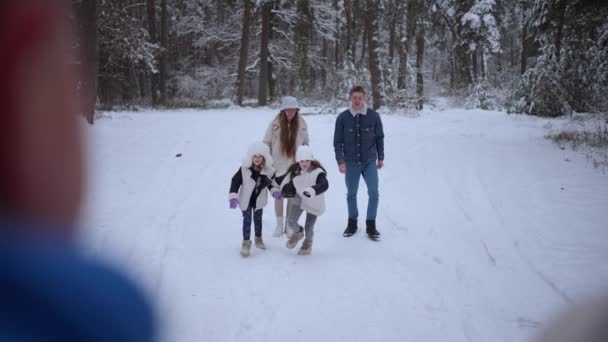 美しい家族は雪の冬の日を歩き 抱擁し 楽しんでいる — ストック動画