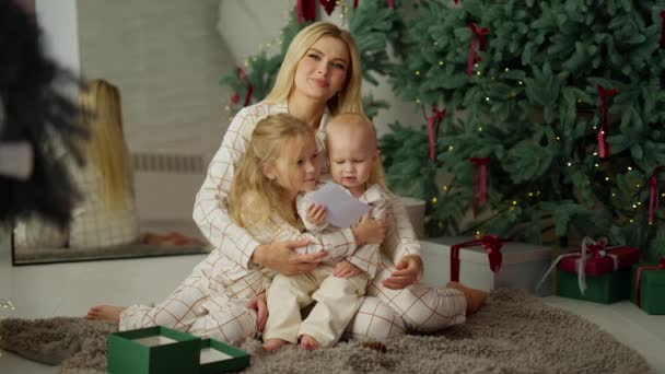아들과 딸이있는 여자가 크리스마스 근처에 상자를 행복한 아이가 상자에서 엽서를 — 비디오