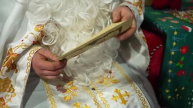 Noel Baba bir çocuğun dileklerini içeren bir mektup tutar ve onu Noel ya da yeni yıl arifesinde yakın plan okur..