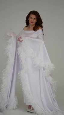 Antika tarzı beyaz ipek elbiseli bir kadın rüzgarda uçuyor..