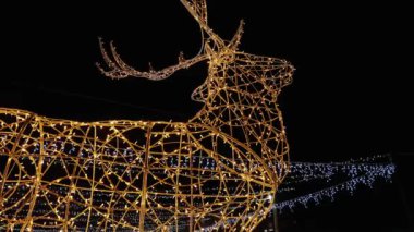 Parlayan sarı bir kemer içinde dönen altın bir çelenk. Güzel ve alışılmadık bir Yeni Yıl dekoru..