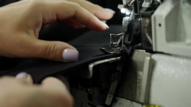 Dikiş makinesinin iğnesi ve basınçlı ayağı kumaşı delip geçer.