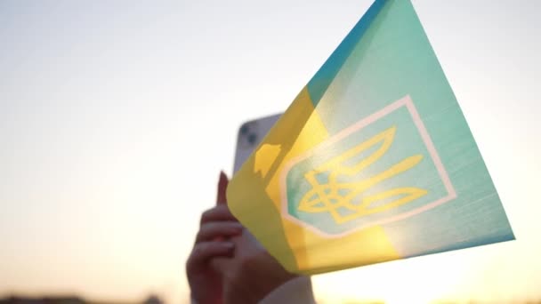 Chica Filma Evento Teléfono Móvil Sostiene Una Pequeña Bandera Ucraniana — Vídeo de stock