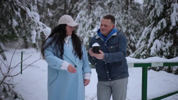 結婚した夫婦が冬の日に森の中を歩き ピクニックでコーヒーを飲んでいる — ストック動画