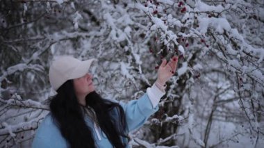 Kış tatilinde olan bir kadın turist kış manzarasının tadını çıkarıyor.