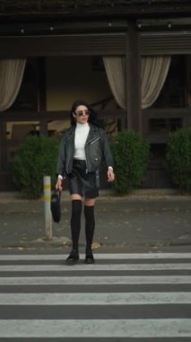 Şehre giden yolda gülümseyen çekici bir kadın. Yaya geçidinde yürüyen iş kadını. Mutlu bir bayan iş görüşmesi için acele eder..