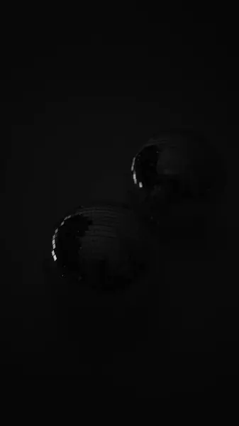 Yansıyan, hareket eden, dönen ışınları olan bir disko topu. Beyaz ışıkta ayna disko topu. Siyah arka planda izole disko topu. Yakın çekim aynalı top. Işıkların yansıması