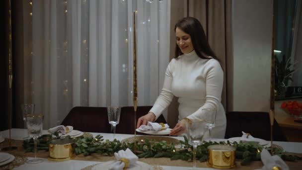 クリスマス 女性は家のサークルでクリスマスのお祝いにテーブルをセットします クリスマス お祝いの装飾のためのディナー 皿およびナプキンのためのクローズアップそして準備 — ストック動画