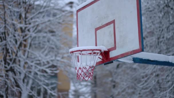 バスケットボールコートは冬の間に雪で覆われています — ストック動画