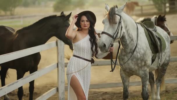 Modna Kobieta Białej Sukience Kapeluszu Stoi Obok Plamistego Szarego Konia — Wideo stockowe