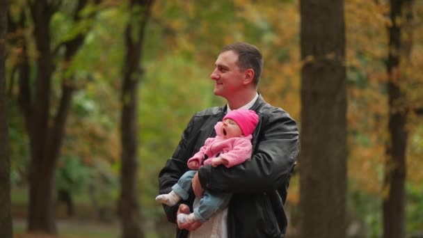 Otec Láskyplně Kolébá Dítě Podzimním Parku Symbolizuje Rodinné Svazky Mír — Stock video