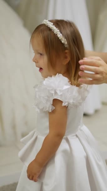 Menina Bonito Vestido Férias Branco Enquanto Experimenta Loja — Vídeo de Stock