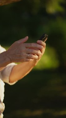 Gri saçlı son sınıf öğrencisi telefonda konuşuyor, şehrin dışındaki bir caddede duruyor..