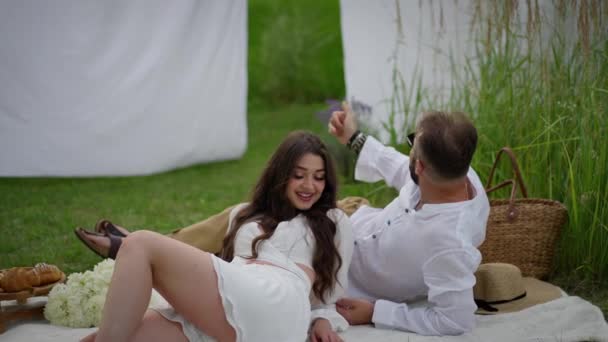 Glückliches Junges Paar Auf Der Picknickdecke Liegend Aneinander Liebevoll Teilend — Stockvideo