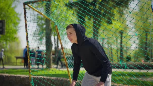 在一个阳光灿烂的夏日 一名少年守门员站在运动场的院子里 穿着运动服守住了球门 — 图库视频影像