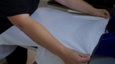 Yazıcı kullanarak kıyafetlere resim çizer.