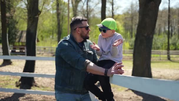 幸せな父親と彼の息子は新鮮な空気の中で週末に一緒に時間を過ごすのが好きです — ストック動画