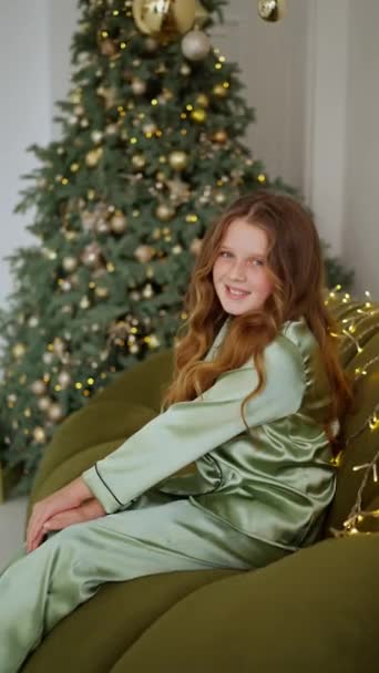 Schattig Klein Meisje Zit Een Pyjama Met Kerstversiering Achtergrond — Stockvideo