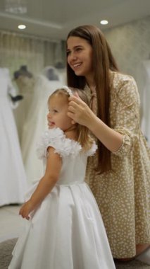 Mutlu anne küçük kızı için şenlikli saç stili yapıyor..