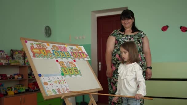 Dziecko Kijem Ręku Przygotowuje Się Pokazania Nauczonych Liczb Pod Nadzorem — Wideo stockowe