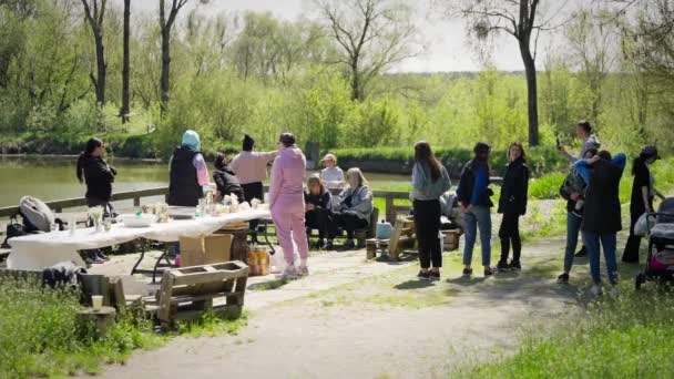 Güneşli Bir Günde Nehir Kenarında Pikniğin Tadını Çıkaran Bir Topluluk — Stok video