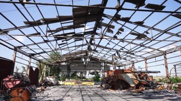 壊れた屋根を介して日光がフィルタリングされ 農業機器が破片の間に廃墟となっている — ストック動画