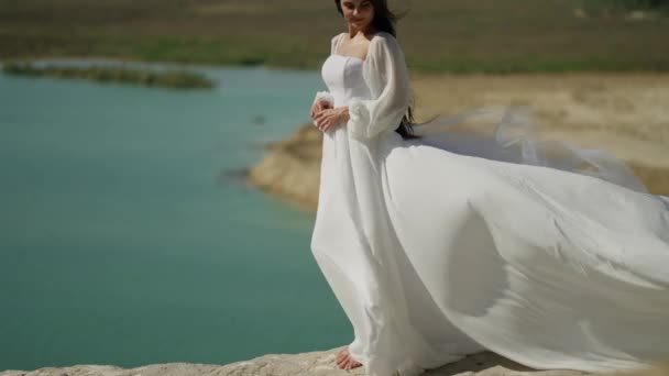 Обнимая Спокойствие Берегу Озера Невеста Белом Платье Останавливается Насладиться Спокойным — стоковое видео
