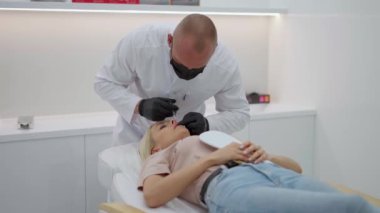 Tıp bürosunda, doktor dudaklara hyaluronik asit enjekte eder..