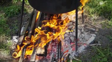 Alevli bir kamp ateşinin üstünde tencere, çölde yemek pişirmek..