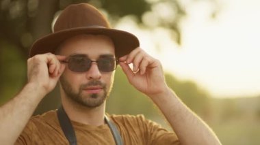 Yaratıcı profesyonel güneş gözlüğünü batan güneşin altın parıltısına göre ayarlar..