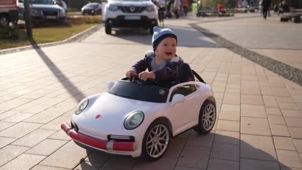 坐在玩具车轮子后面的小男孩的亲密和缓慢的积极情绪 — 图库视频影像