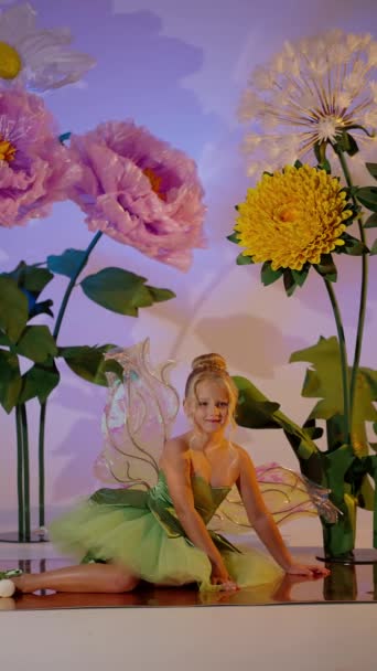 Маленька Дівчинка Булочкою Одягнена Казкове Плаття Оточена Гігантськими Яскравими Паперовими — стокове відео
