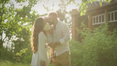 Güneş ışınları mutlu aileyi sarıyor. Birlikte eğleniyorlar..