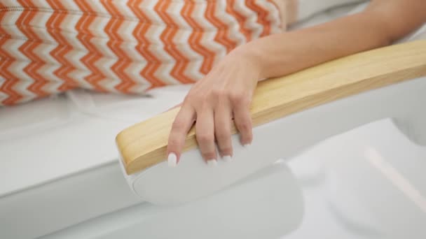 优雅的女性手 修指甲时不显眼地放在美容院床的木制扶手上 强调放松的时刻 — 图库视频影像