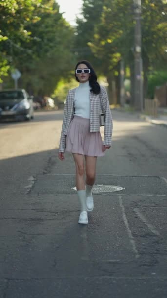 女性は遊び心と短いスカートを身に着けているエレガンスを兼ね備え ジャケットは驚異的で白いスニーカー — ストック動画